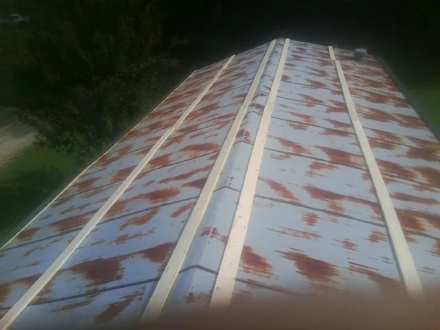 Rusted metal roof panels with new wood purlins before replacement — Storm Damage Roof Repair in Pilger by Roofing Brothers